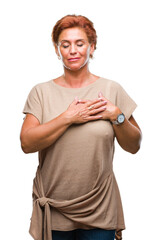 Sticker - Atrractive senior caucasian redhead woman over isolated background smiling with hands on chest with closed eyes and grateful gesture on face. Health concept.