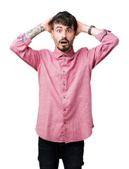 Sticker - Young handsome man wearing pink shirt over isolated background Crazy and scared with hands on head, afraid and surprised of shock with open mouth