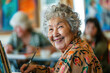 Elderly woman smiling while painting with other friends in an art class at the community center