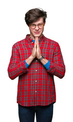Canvas Print - Young handsome man wearing glasses over isolated background praying with hands together asking for forgiveness smiling confident.