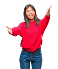 Poster - Young asian woman wearing winter sweater over isolated background looking at the camera smiling with open arms for hug. Cheerful expression embracing happiness.