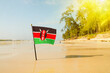 flag of Kenya on a beautiful clean white sand beach. The concept of recreation in the Kenyan Republic.