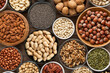 Peanut,hazelnut,walnut,almonds,pistachio,sunflower,pumpkin,chia,pecan and cashew mixed healthy nuts and seeds in various bowls on wooden background.Top view.