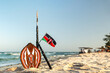 spear of Masai and the national flag of Kenya on the background of a beautiful beach landscape. the concept of African tourism.