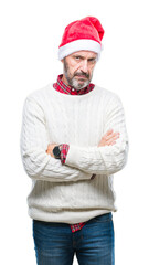 Wall Mural - Middle age hoary senior man wearing christmas hat over isolated background skeptic and nervous, disapproving expression on face with crossed arms. Negative person.