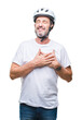 © Krakenimages.com - Middle age senior hoary cyclist man wearing bike safety helment isolated background smiling with hands on chest with closed eyes and grateful gesture on face. Health concept.