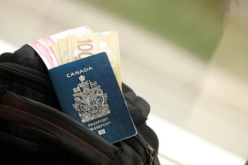 Wall Mural - Canadian passport and dollar money bills with airline tickets on backpack close up