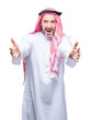 © Krakenimages.com - Senior arab man wearing keffiyeh over isolated background looking at the camera smiling with open arms for hug. Cheerful expression embracing happiness.