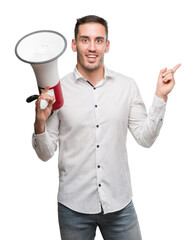 Sticker - Handsome young man holding microphone very happy pointing with hand and finger to the side