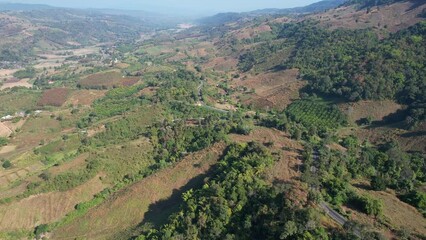 Wall Mural - Aerial view of a car running along the mountain road in countryside by drone