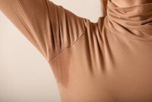 Close Up Image Of Woman In Beige Cotton Turtleneck With Sweat Patch Under Armpit