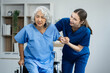 young caregiver assists her elderly woman patient at a nursing home. senior woman is assisted by a nurse at home.