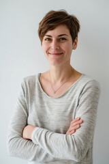 Wall Mural - female startup employee, 26 years old, french, smiling, casual attire, arms crossed, white background 