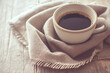 ウッド調のカフェのテーブルの上の柔らかな布に包まれた一杯のコーヒー