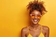 Vibrant young woman with curly hair, smiling in summer attire against a yellow background. Joyful, fresh, upbeat mood. Generated AI