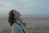 Fototapeta Na ścianę - Beautiful woman relaxing on the beach taking a deep breath