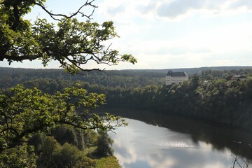 Burgk Castle and trees on the riverbanks of Saale under the cloudy sky