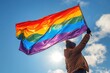 Boy holding a colorful rainbow flag.