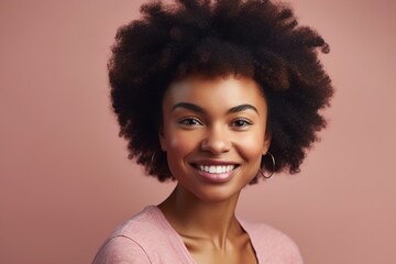 Wall Mural - A woman with curly hair is smiling and wearing a pink shirt