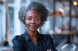 © Aris - African senior business woman in formal shirt, smile in modern office