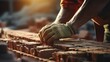 Close-up of the hands of an industrial bricklayer installing bricks on a construction site