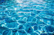 The blue water of the swimming pool is filled with ripples, reflecting light and creating beautiful patterns on its surface. Water tile background