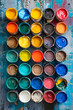 Group of paint cans on wooden table.