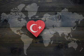 Wall Mural - wooden heart with national flag of turkey near world map on the wooden background.