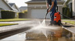 Pressure washing driveway. Close up on water splash and worker in worker boots cleaning driveway with pressure washer.