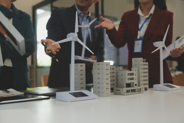 Wall Mural - Close-up at tablet, Engineers pointing at tablet with their hands. To jointly design the use of renewable energy with wind and solar energy. Concept of using renewable energy.