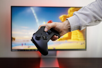 A black gamepad in the hands of a man. Video game gamepad in hand