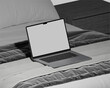The sleek, silver laptop sits atop the desk, its illuminated keyboard casting a soft glow as it hums with productivity, a hub of innovation in the modern workspace.