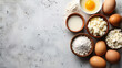 Top view of baking ingredients with eggs, flour, milk, and cottage cheese on a textured white background with copy space.