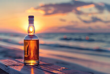 Bottle Of Whisky On The Beach With The Sea And Sunset In Background