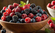 A bowl filled with a vibrant mix of fresh berries against a dark background. The ripe strawberries, blackberries, raspberries, and blueberries create a visually appealing and healthy fruit mix.
