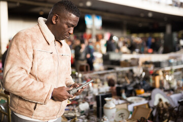 Wall Mural - Man looking at used items at a flea market