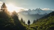 Sunset in the mountains. A silhouette of person walking alone in a calm rainforest surrounded by lush green large trees with snow-capped peaks. Hiking in the forest. Summer hike in mountains.