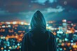 A person in a hoodie looking out over a city at night. Suitable for urban lifestyle concepts