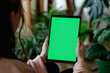 App view beside a shoulder of a woman holding an ebook with a completely green screen