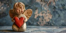 A Statue Of An Angel Holding A Red Heart. Perfect For Romantic Concepts