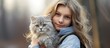 Girl with gray cat outdoors holding carrier on a stroll