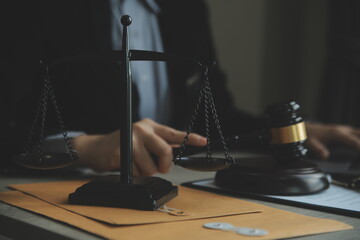 Business and lawyers discussing contract papers with brass scale on desk in office. Law, legal services, advice, justice and law concept picture with film grain effect