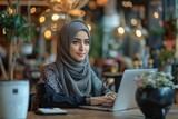 Fototapeta  - Portrait of a successful Muslim business woman in a cafe with a laptop, women in hijab, remote worker, student