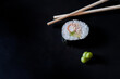 Maki présenté avec wasabi et baguette sur fond noir, cuisine japonaise et asiatique