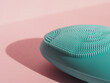 Facial cleansing brush for skin hygiene. Blue silicone facial brush on pink background. Skincare and Wellness concept. Brush for beauty skin, massage, lifting, anti-aging. Horizontal close-up.