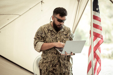 Wall Mural - Soldiers in camouflage uniforms planning on operation in the camp, soldiers training in a military operation