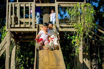 Wall Mural - Two brothers embrace each other down a handmade wooden slide.