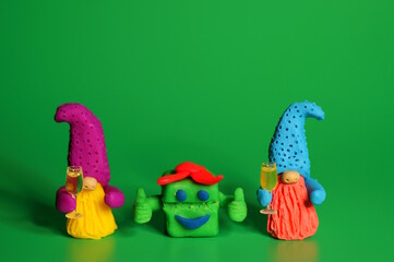 Two toy dwarfs made of plasticine with glasses of champagne. New Year's holidays and Christmas. Decorations and decorations.