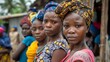 Women of Sierra Leone. Women of the World. A group of African women with colorful headwraps looking at the camera with serious expressions set in a rural village backdrop.  #wotw