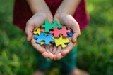 Fototapeta Do akwarium - Child holding colorful puzzle pieces, autism awareness concept.